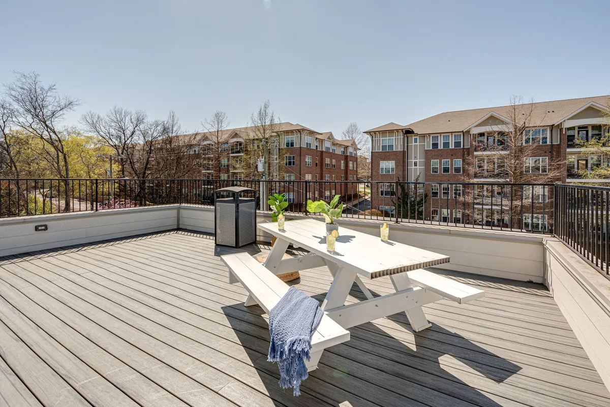 This image features an inviting outdoor dining table surrounded by lush green plants, ideal for group gatherings, al fresco dining, or relaxing with friends. It showcases the type of shared rooftop/outdoor setting described in the section.