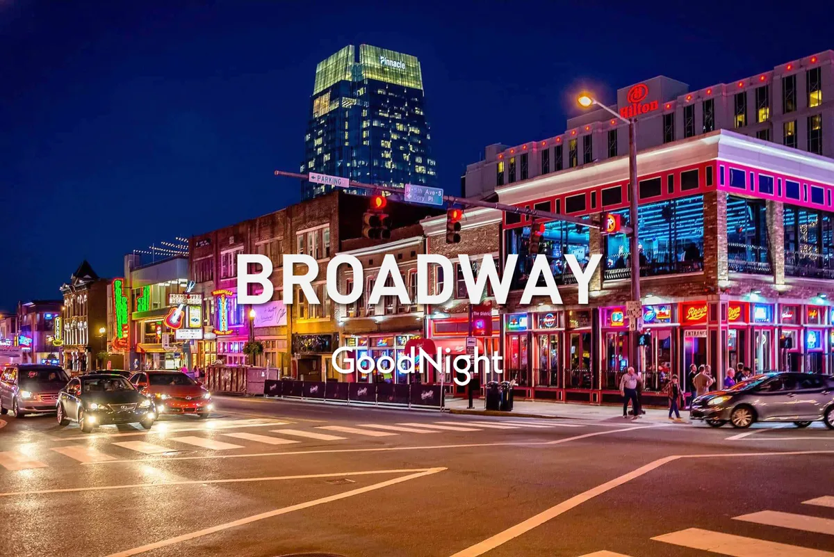 A lively Nashville street scene after dark, featuring glowing neon signs, a bustling crowd walking along the sidewalks, cars passing by, and tall buildings. The vibrant energy and festivity of the neighborhood are palpable, with clear associations to nightlife, live music, and entertainment.